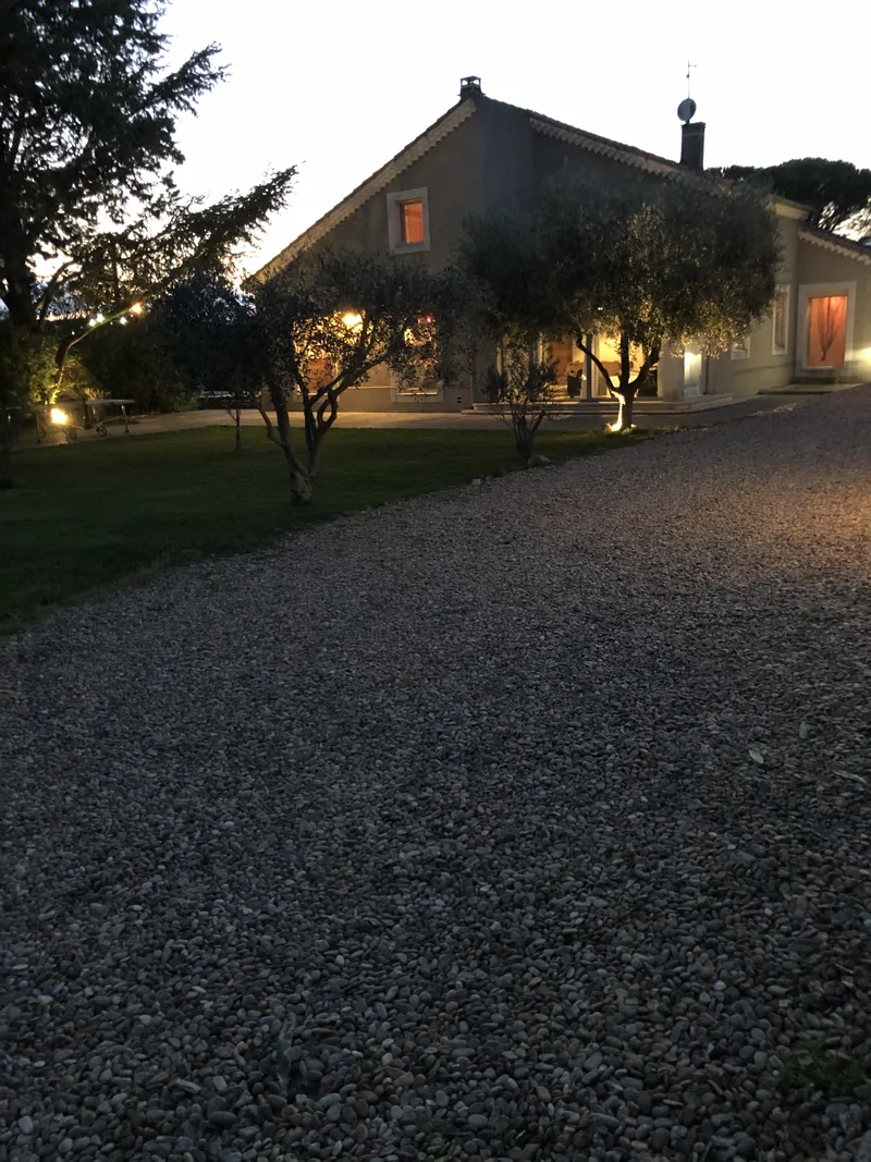 Façade illuminée de nuit sous les oliviers